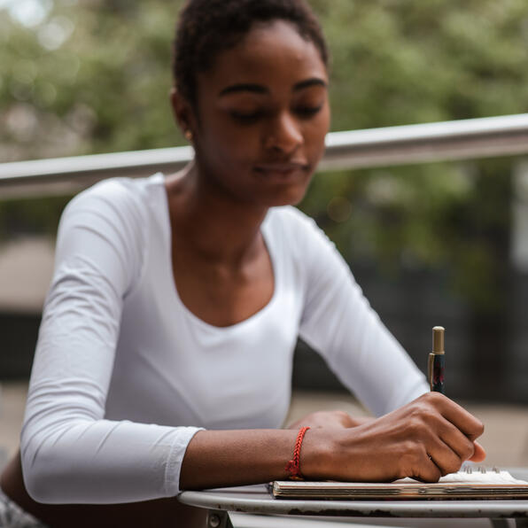 A brown skinned girl writting